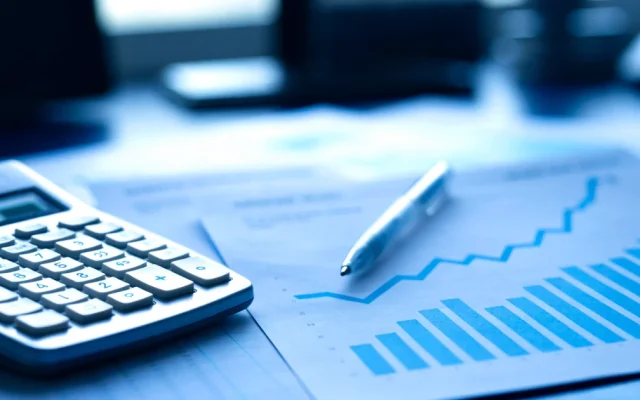 Calculadora e relatórios com gráficos de crescimento na mesa, tema IRE no Paraguai